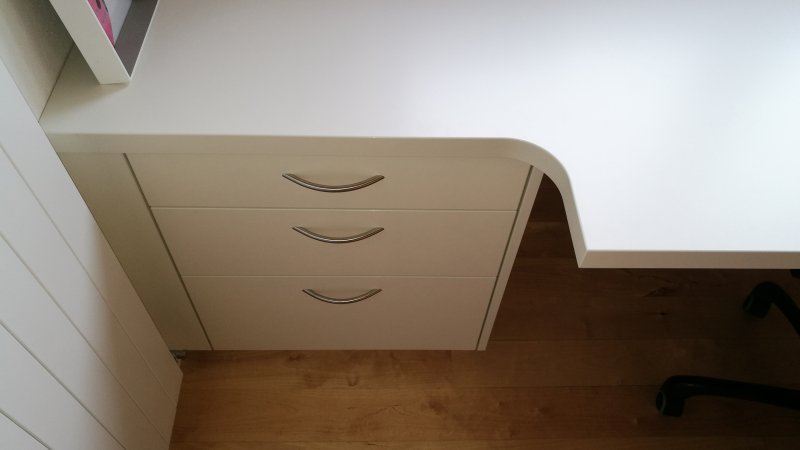 Massgeschneiderter Schreibtisch in schmalen Büro optimal eingepasst für maximale Arbeitsfläche ohne einzuengen.