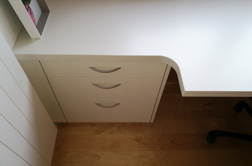 Massgeschneiderter Schreibtisch in schmalen Büro optimal eingepasst für maximale Arbeitsfläche ohne einzuengen.